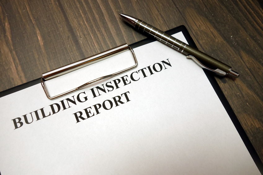 Clipboard with building inspection report and pen on desk Inspection Report