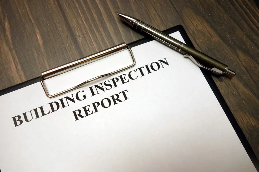 Clipboard with building inspection report and pen on desk Inspection Report